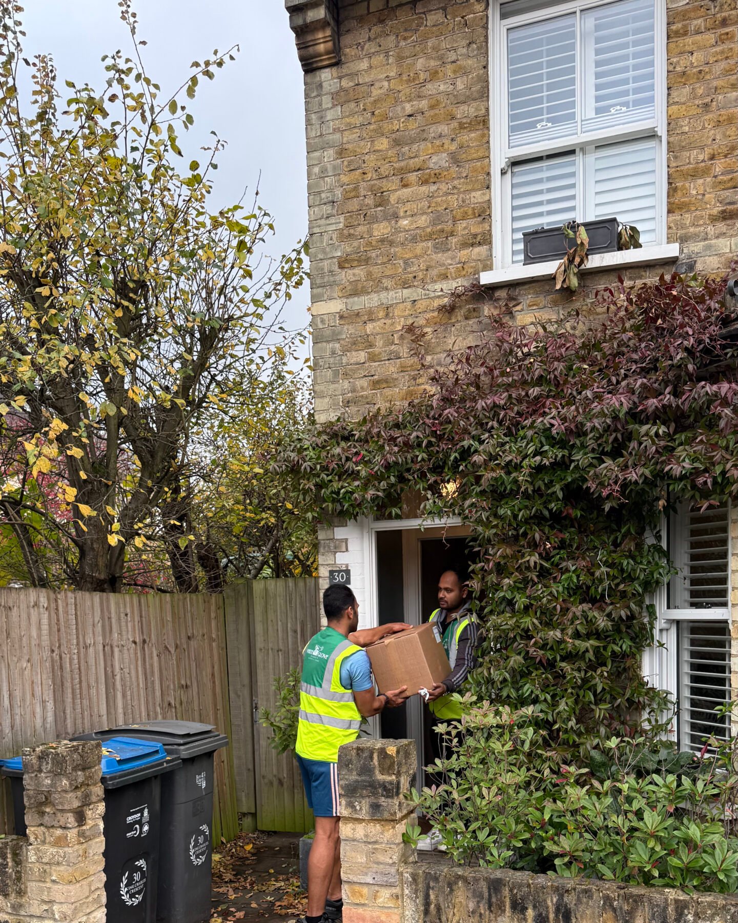 White Glove Surrey movers carrying a box into a home
